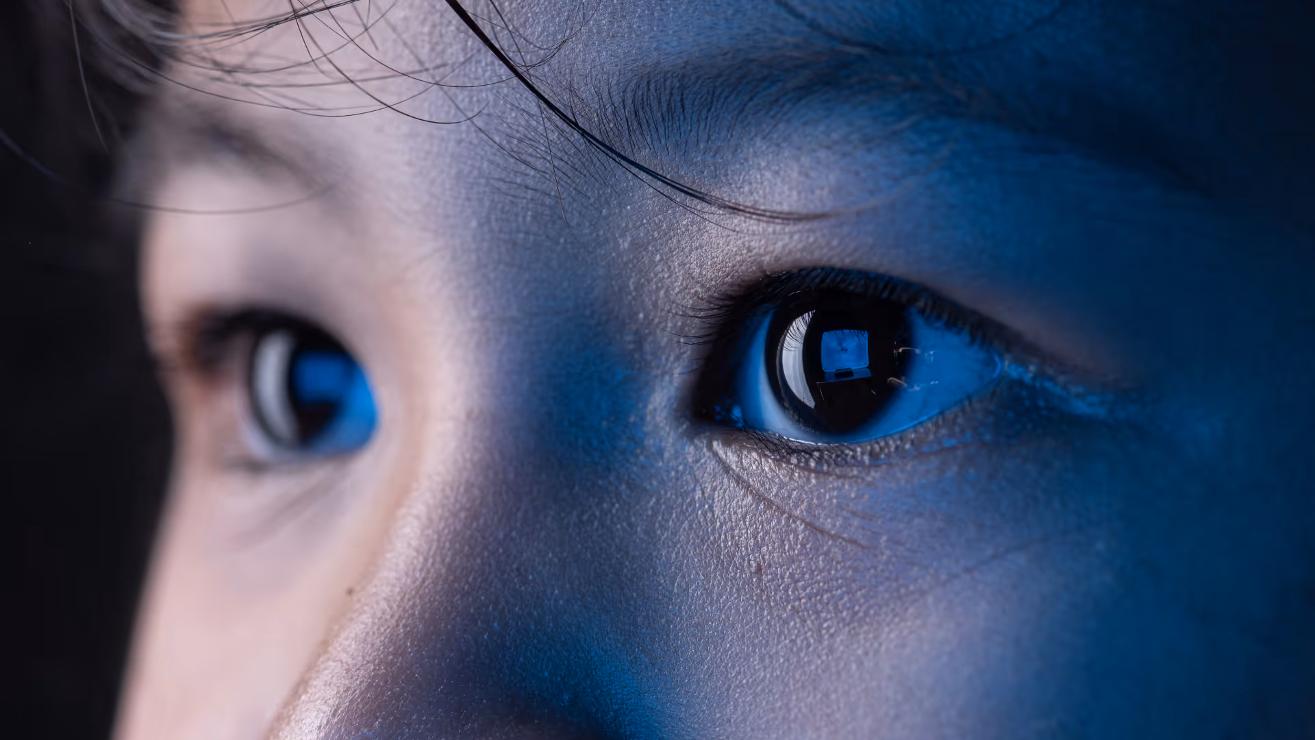 close up photo of child with blue light reflection