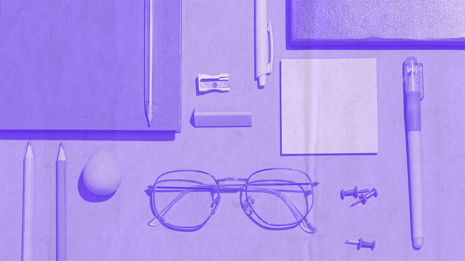 Top view eye glasses and school supplies on top of a desk
