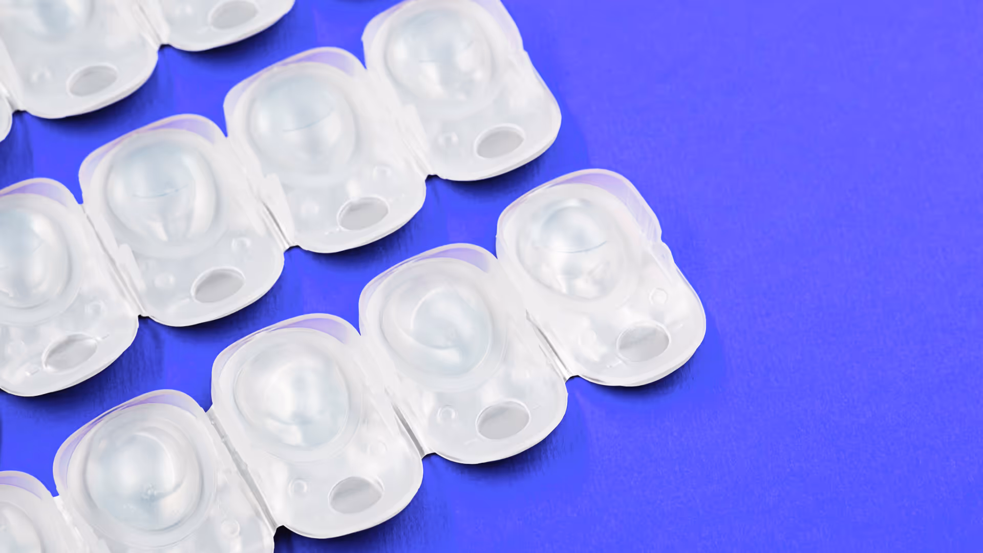 Contact lens in disposable containers on purple desk background
