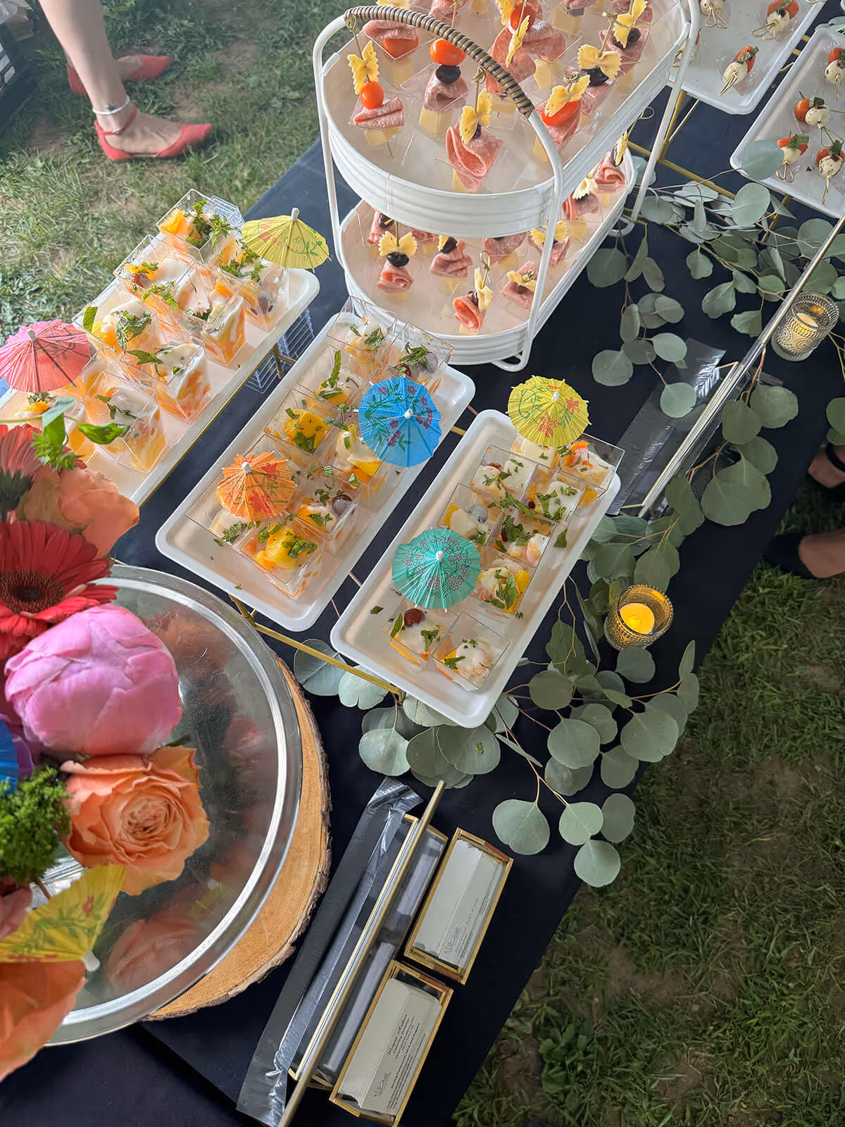 table of sweet and savory starters, decorated with mini umbrellas and flowers - special occasions concept