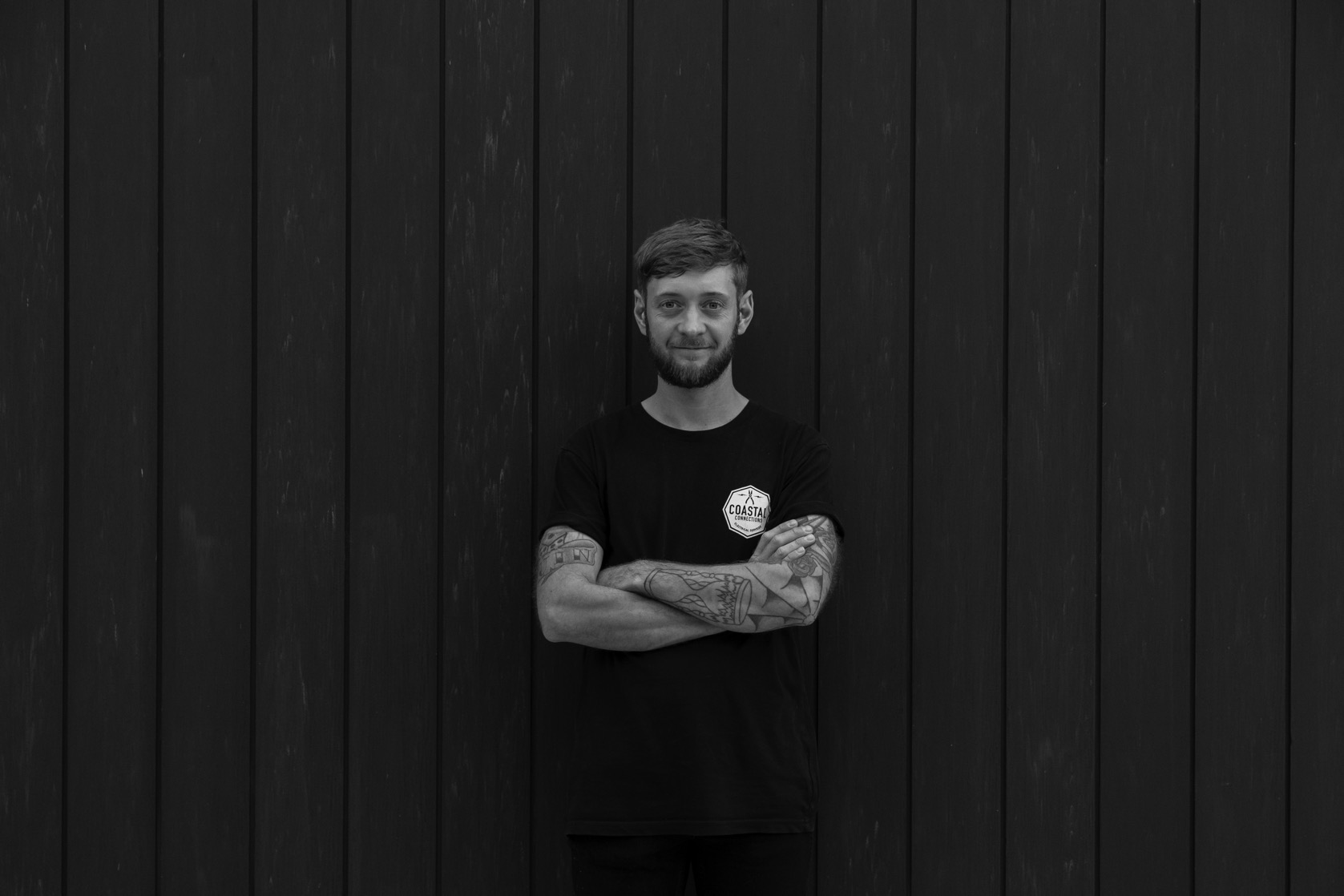 Director Joe Kelly standing against timber wall