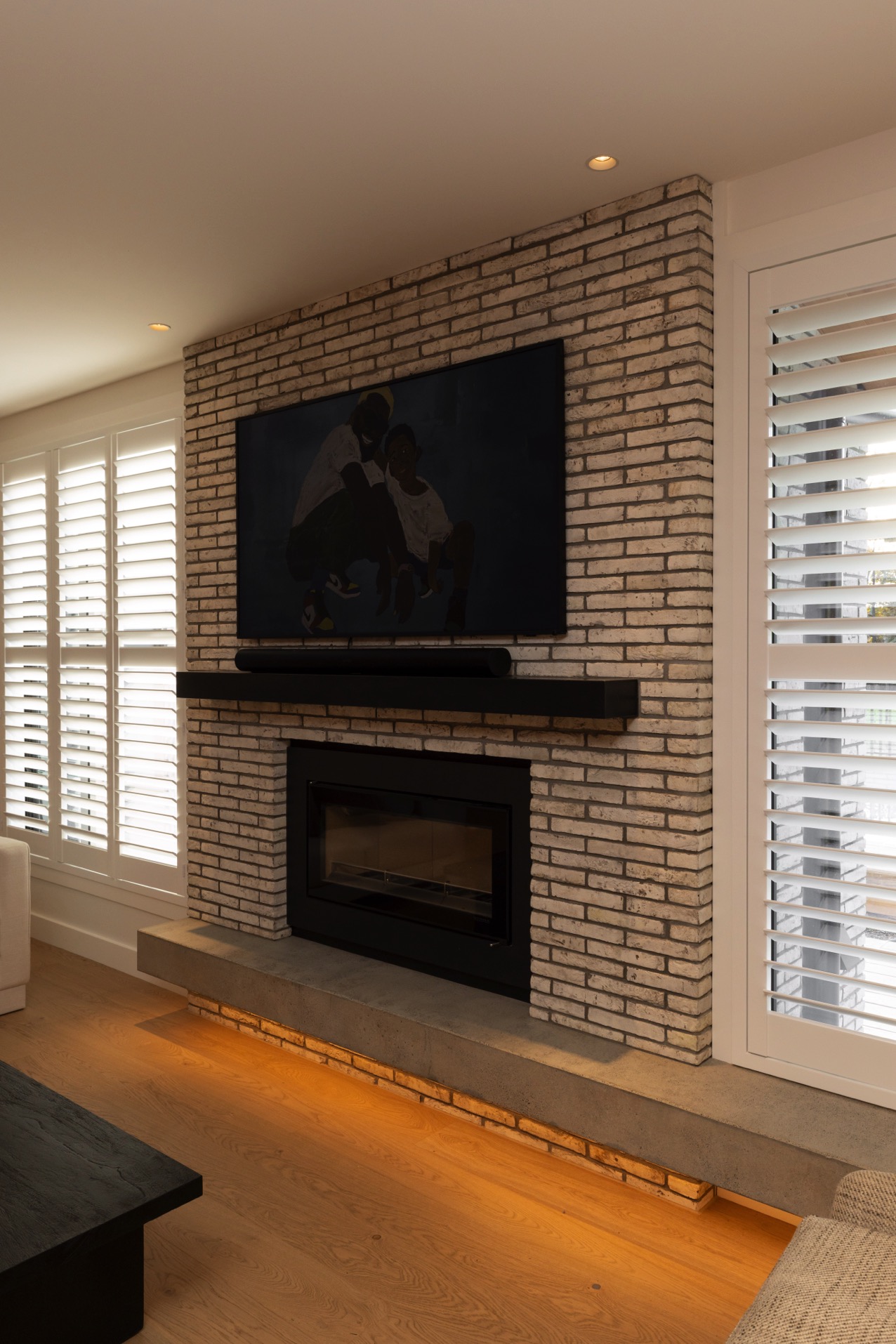 Wall mount TV installed above fire place against brick wall 