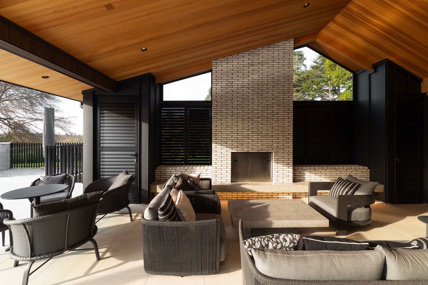 Exterior Lounge Area with timber ceiling and brick fireplace
