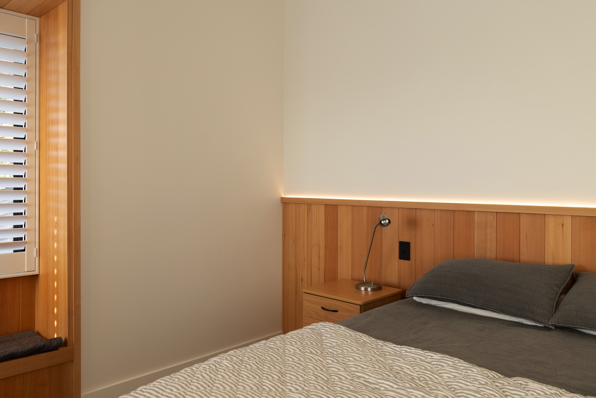 Modern bedroom with LED lighting installed behind bedhead