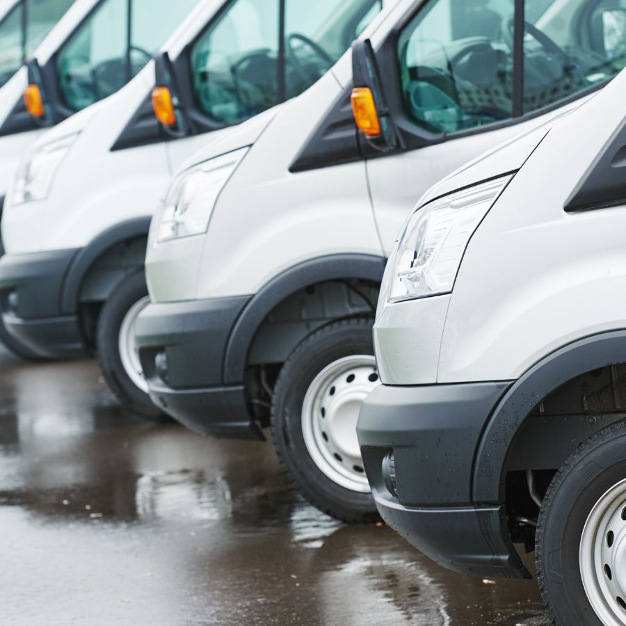 a row of commercial white vans used on a page about business vehicle loans