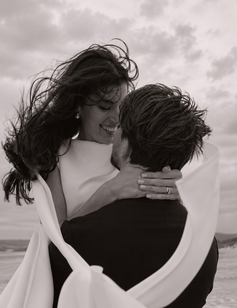 bride and groom share hugs on the beach