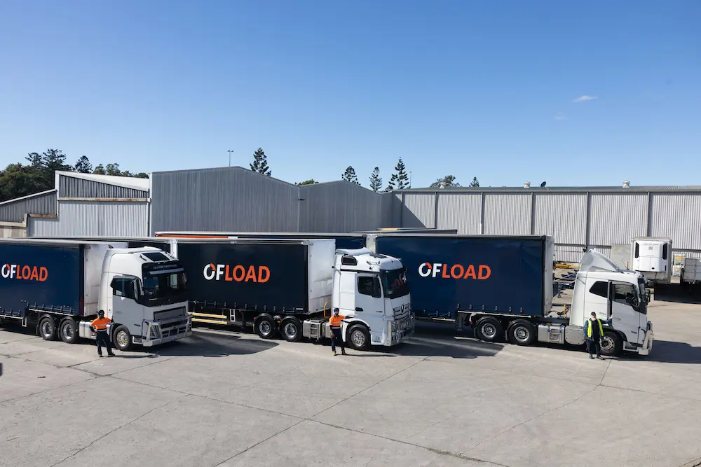 Ofload freight trucks and drivers outside a warehouse facility in Australia.