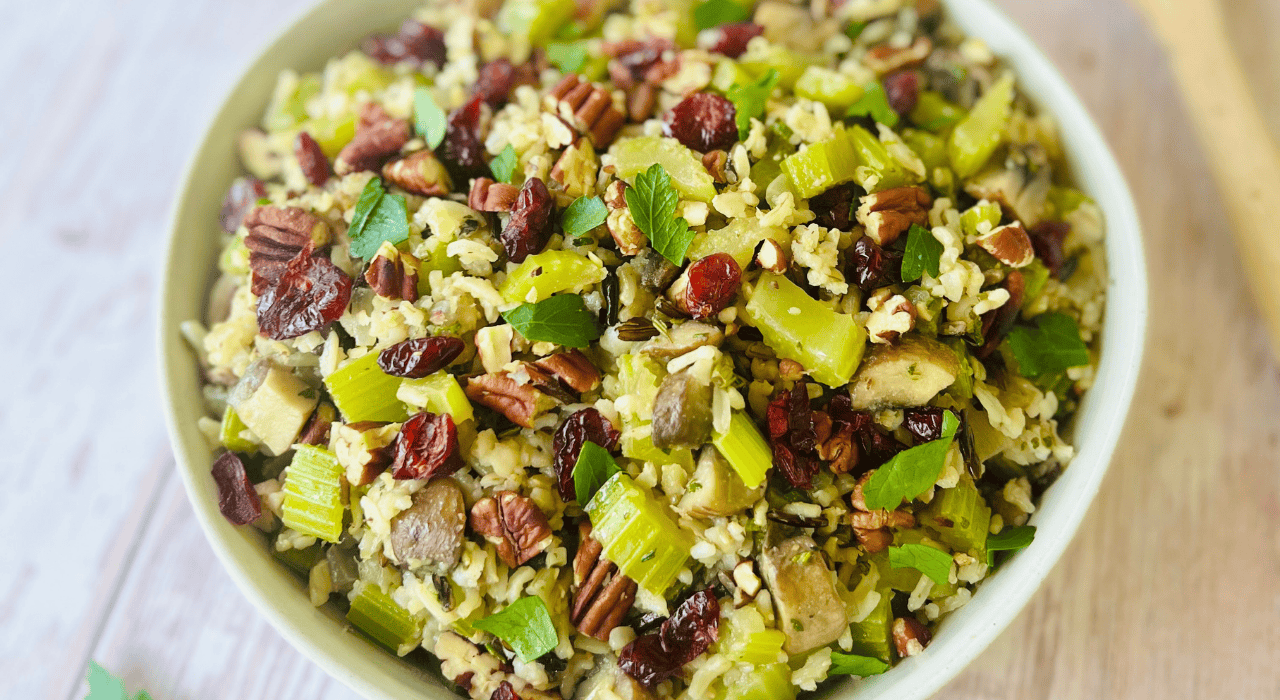Wild rice stuffing served in a rustic bowl with herbs and cranberries, perfect for a festive holiday meal.