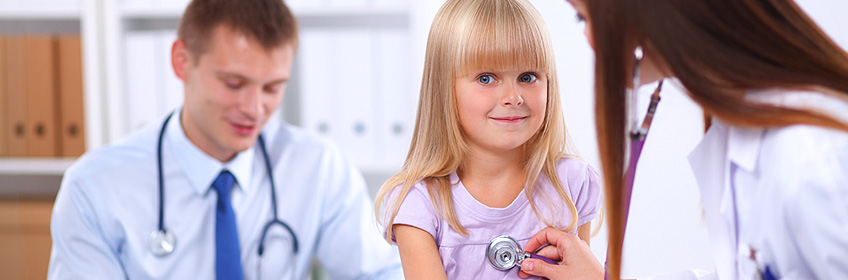 A little girl getting her heart listened to at the doctor's office