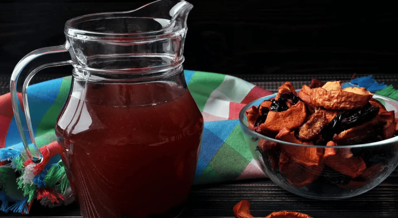 A pitcher of Uzvar next to a bowl of dried fruit