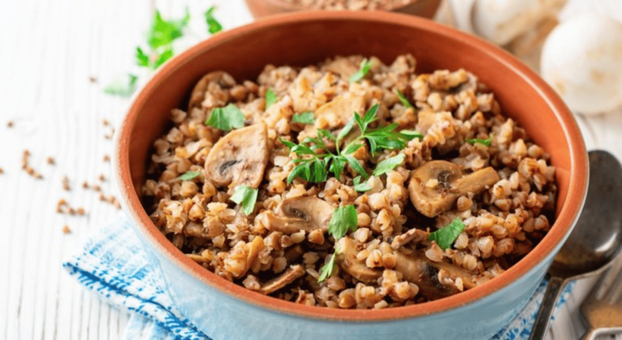 A bowl of buckwheat and mushrooms garnished with parsley