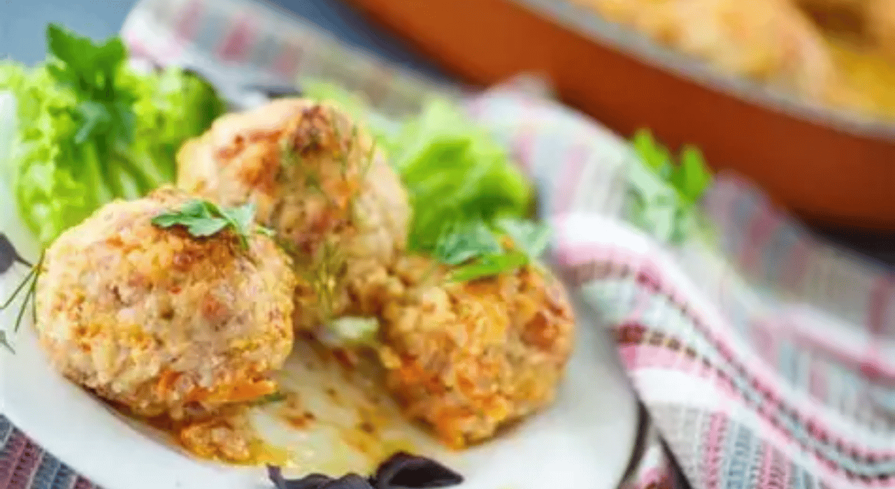 Three chicken meatballs on a plate with a lettuce garnish