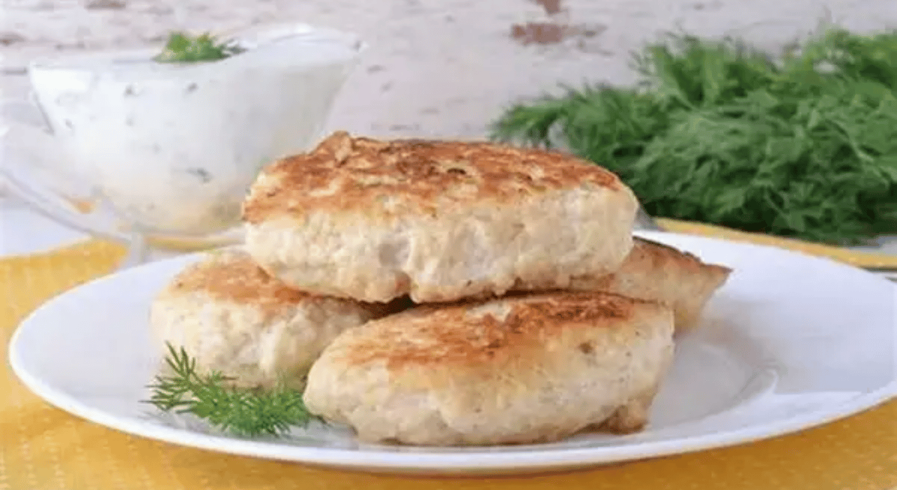 3 baked turkey cutlets (patties) stacked on a white plate garnished with dill