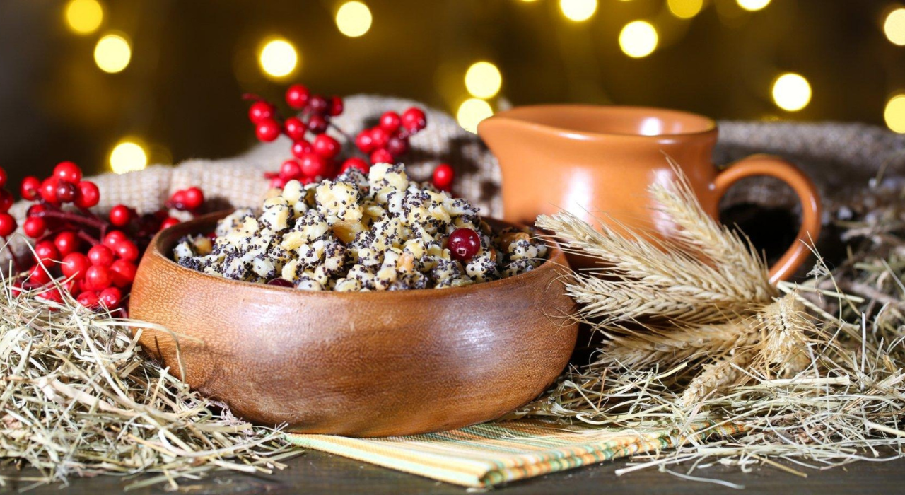 Barley and poppy seed pudding in a wooden bowl surrounded by holiday decor.
