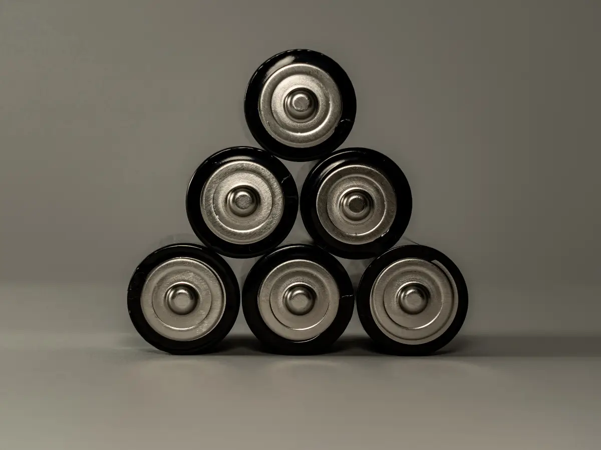 A group of batteries sit on top of one another in the shape of a triangle
