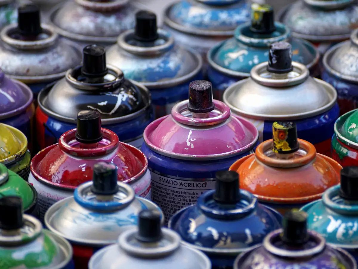 A group of different coloured spray paint cans