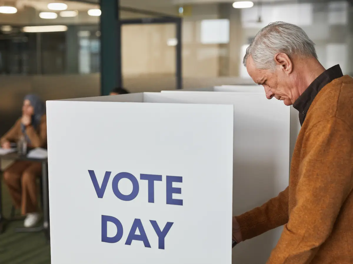 A man stands at a polling station booth