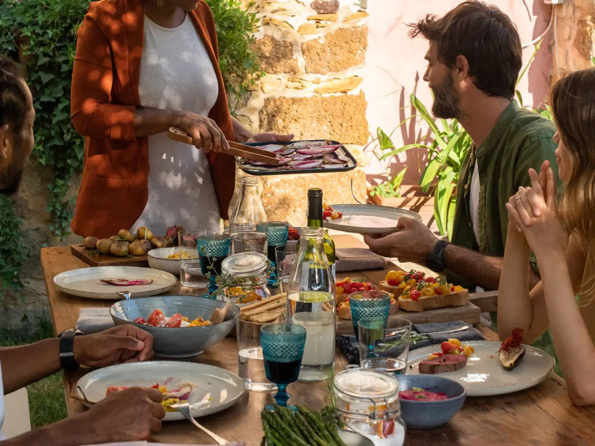 Friends gather around a table full of food