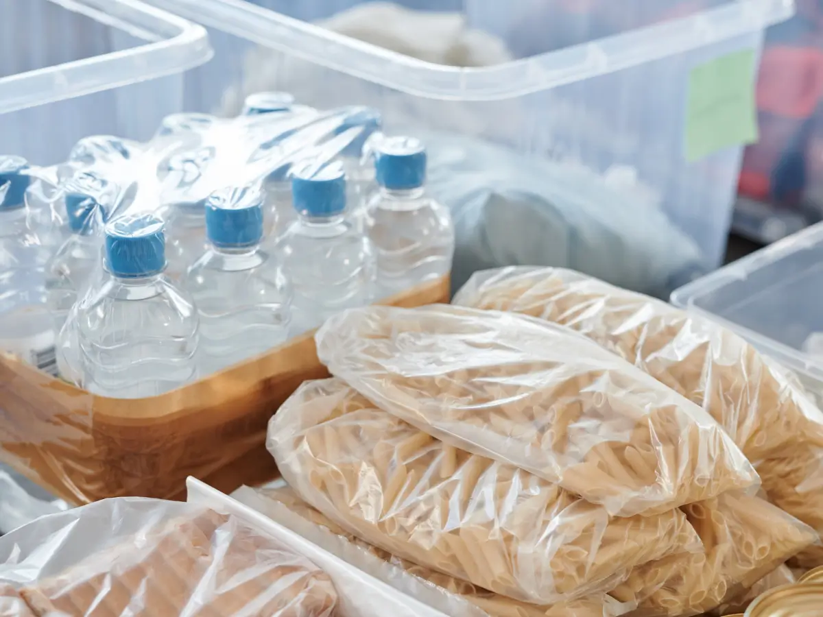 Plastic wrapped water bottles and plastic wrapped food sit on a counter