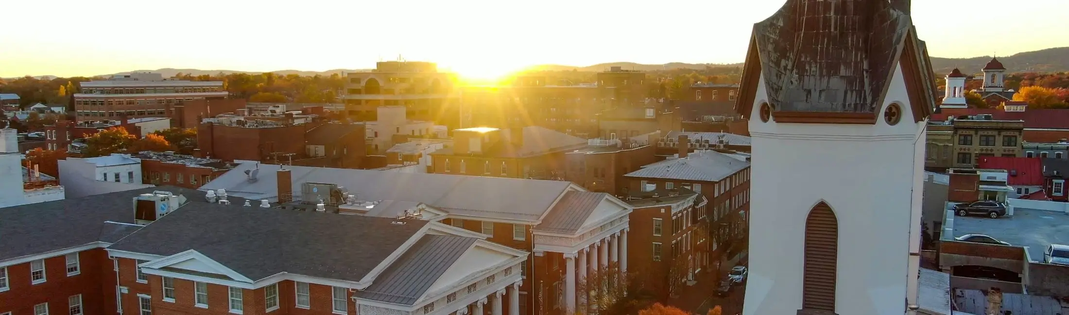 A view from a high up building over a city as the sun sets. 