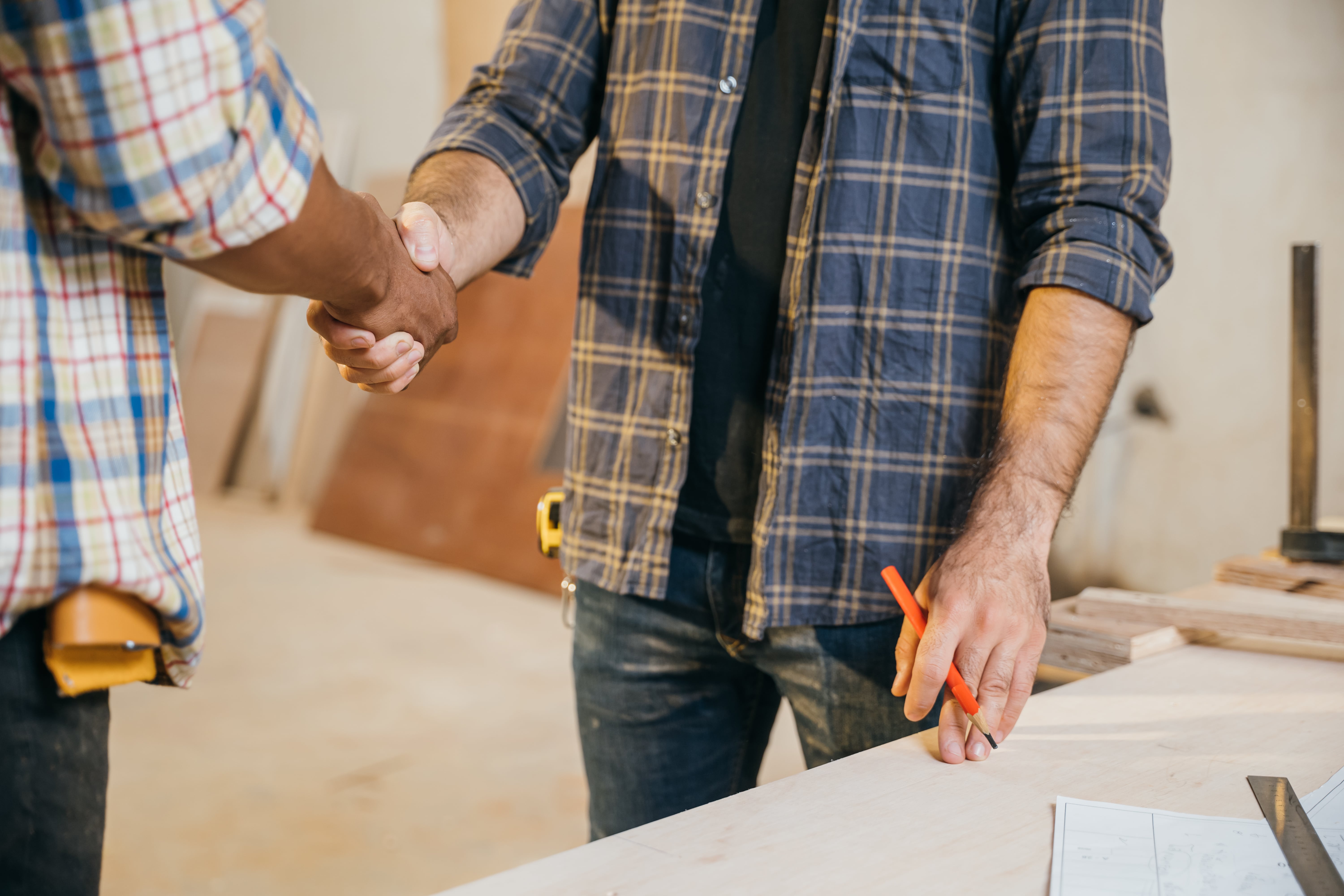 Contractor and client shaking hands, finalizing an agreement or celebrating project progress. 