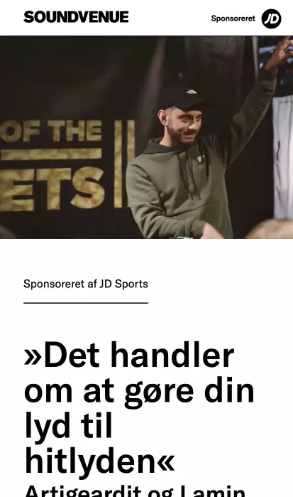 Man in a hoodie and cap speaking on stage at a Soundvenue event.