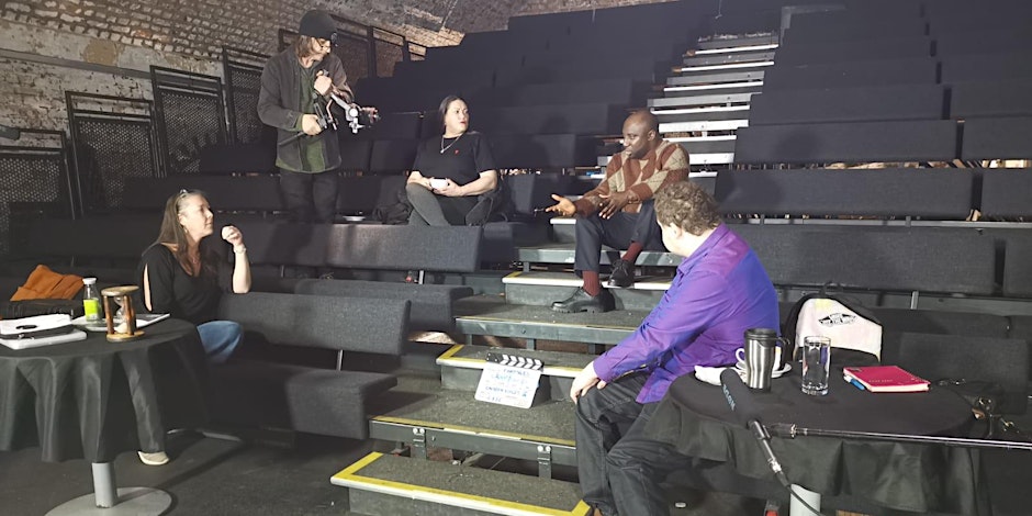 Five people speaking in a theatre