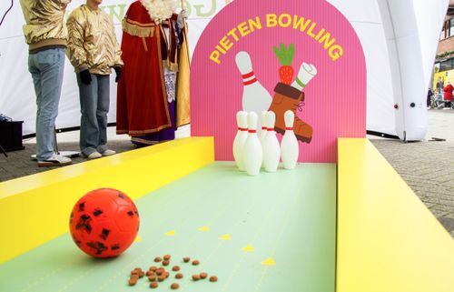 Kinderen spelen Pietenbowling met rode bal en kleurrijke decorbaan in Winkelcentrum Getsewoud
