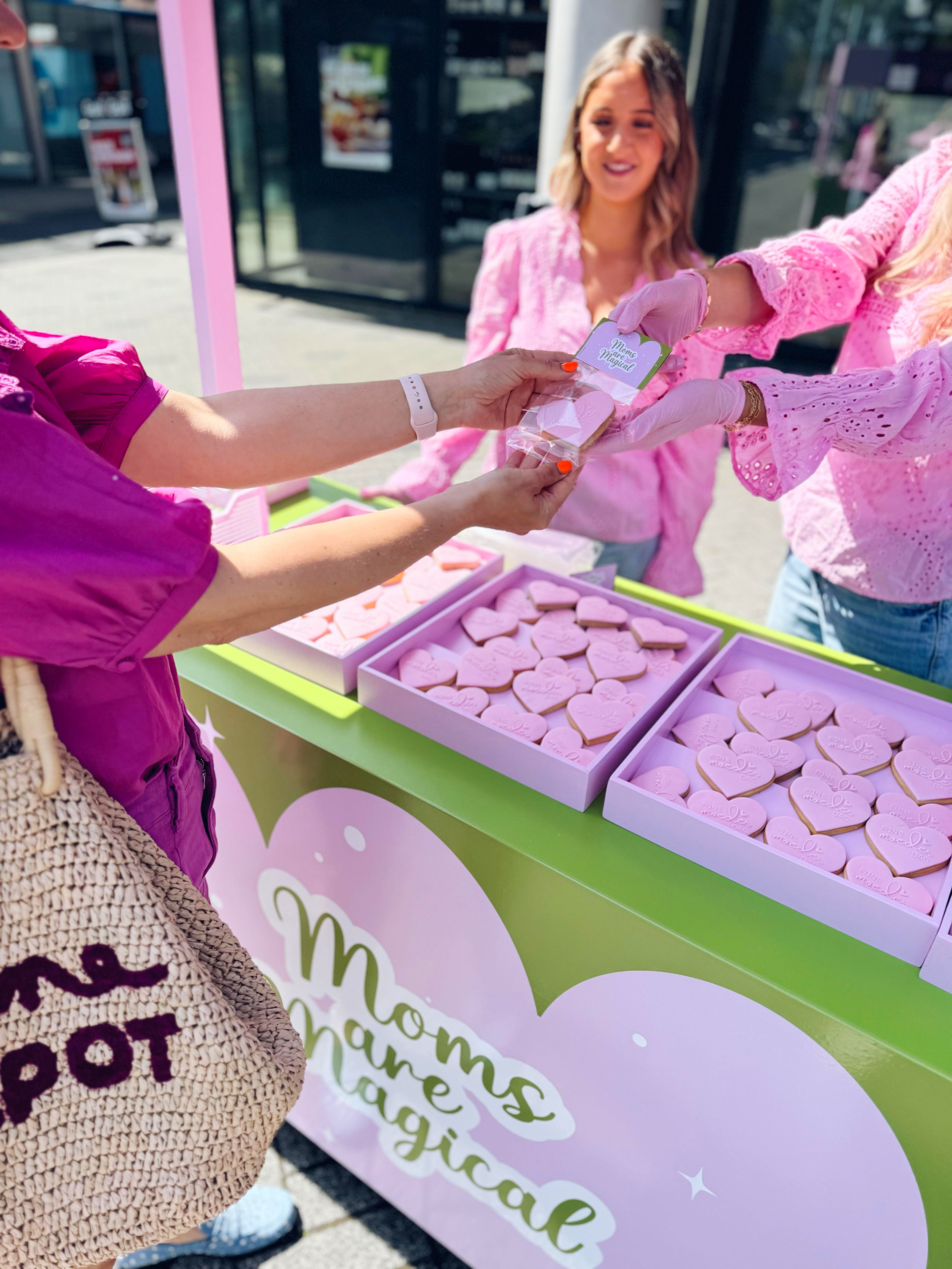 Bezoeker ontvangt een snoephart tijdens de Moederdagactivatie in winkelcentrum, uitgevoerd door Bryte Creators.
