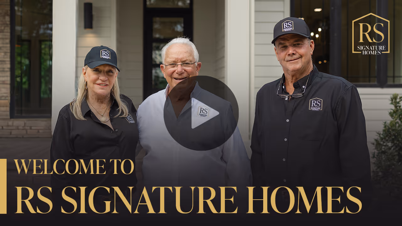 RS Signature Homes team members smiling in front of a luxury home, with a play button overlay for an introductory video.
