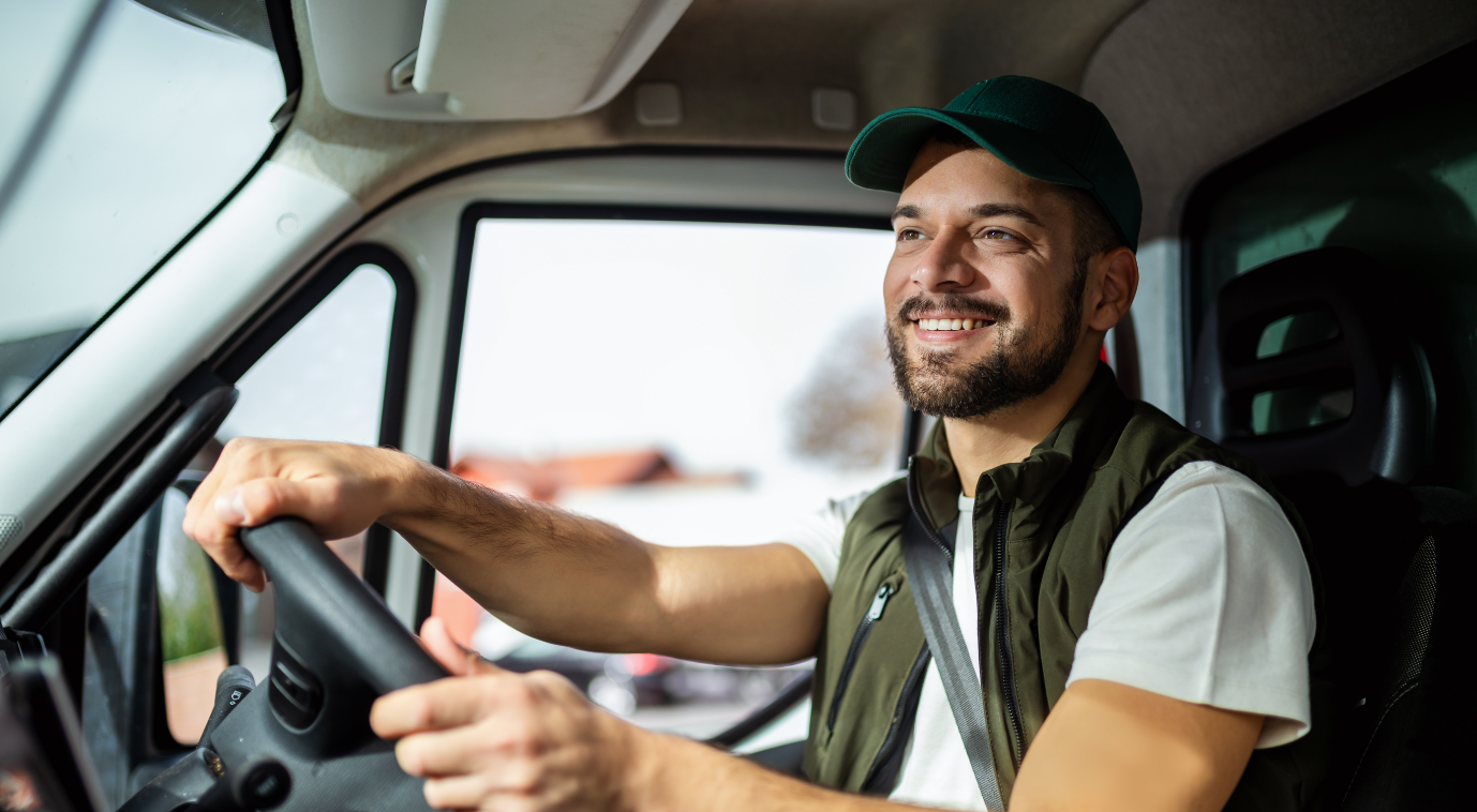 Smiling truck driver at the wheel of a semi truck