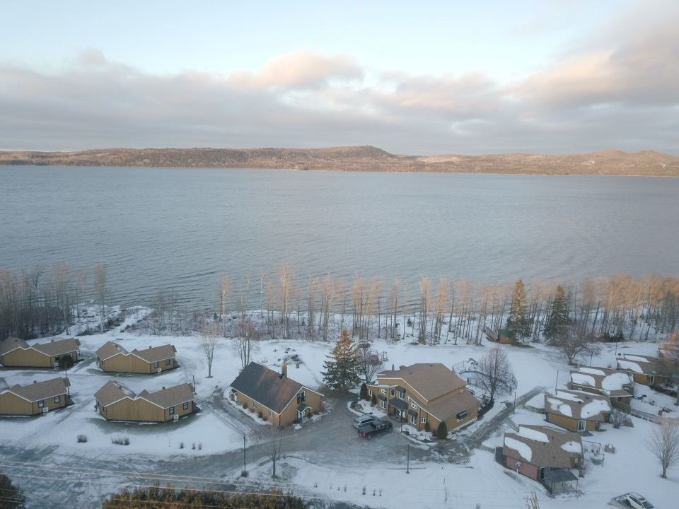 Chalet 16 – grande chambre lumineuse avec lit queen et grande fenêtre offrant une vue relaxante.