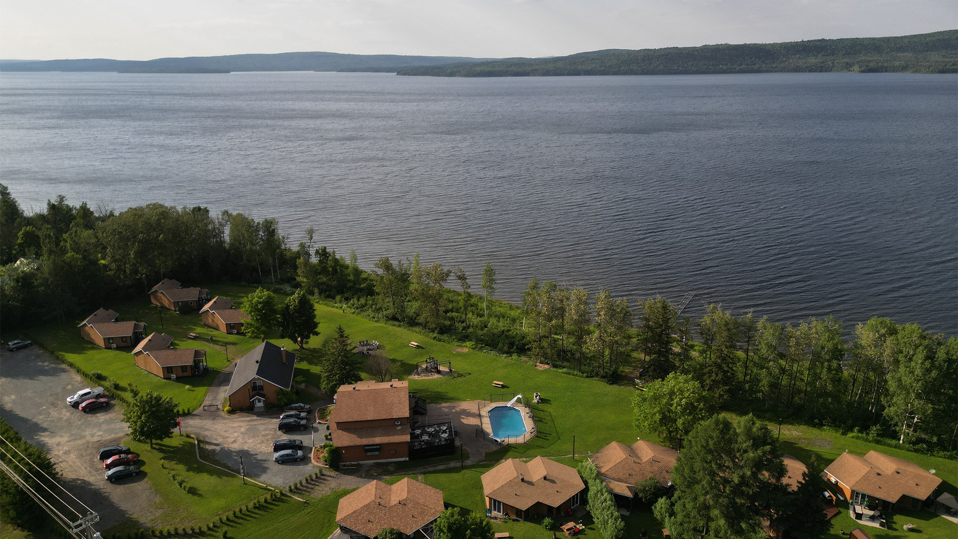 Autre angle de vue de l'intérieur du chalet 16, mettant en avant la cuisine, la salle à manger et le salon dans un espace ouvert.