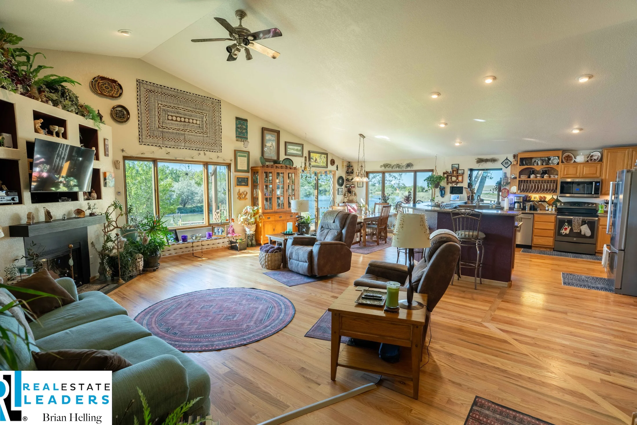 Open living room with timber floors and windows toward the deck
