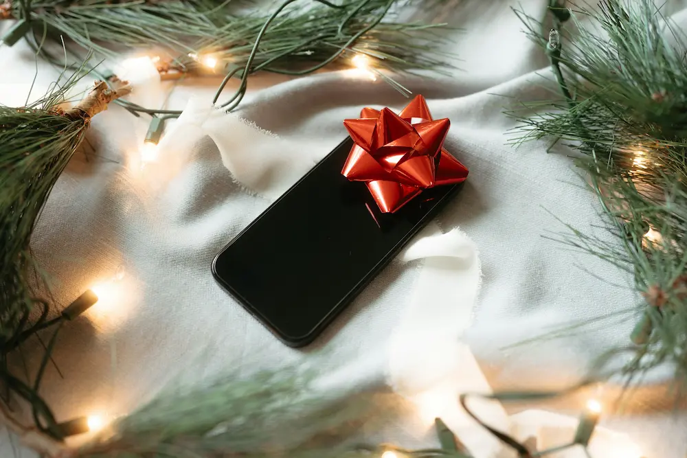 a mobile phone on a table with christmas decorations