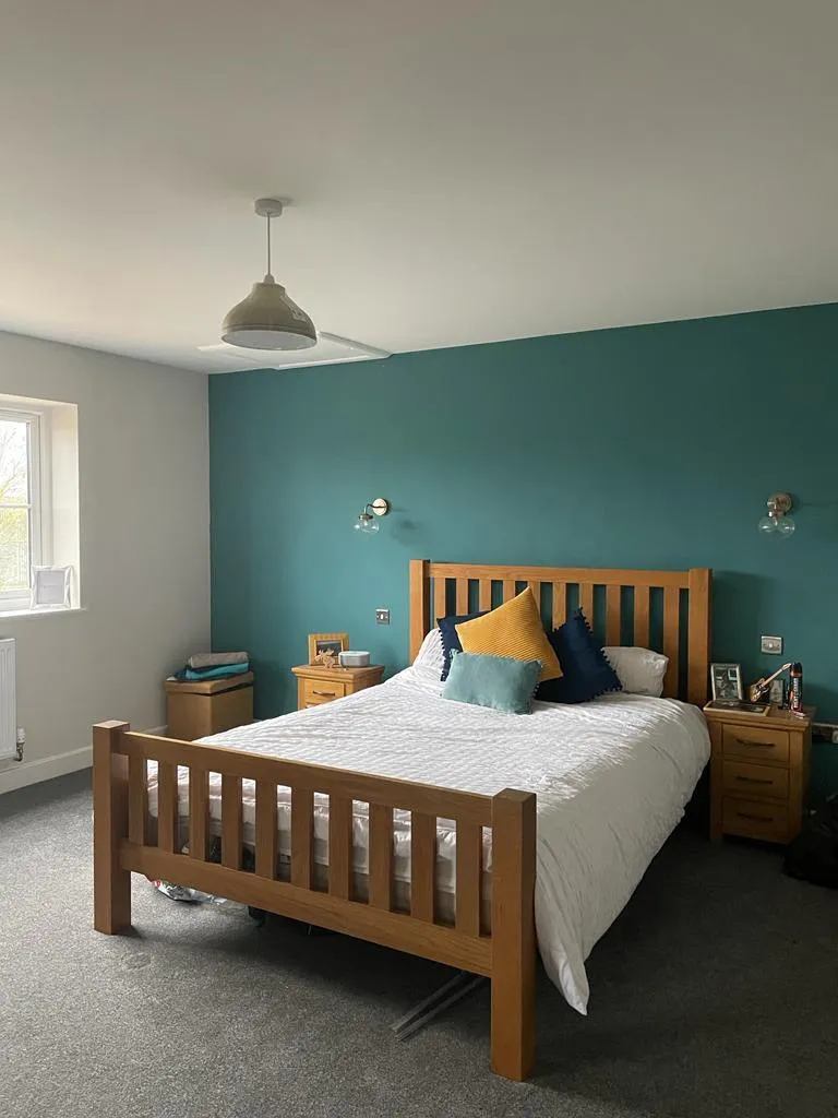 A bedroom with a bed and a lamp.