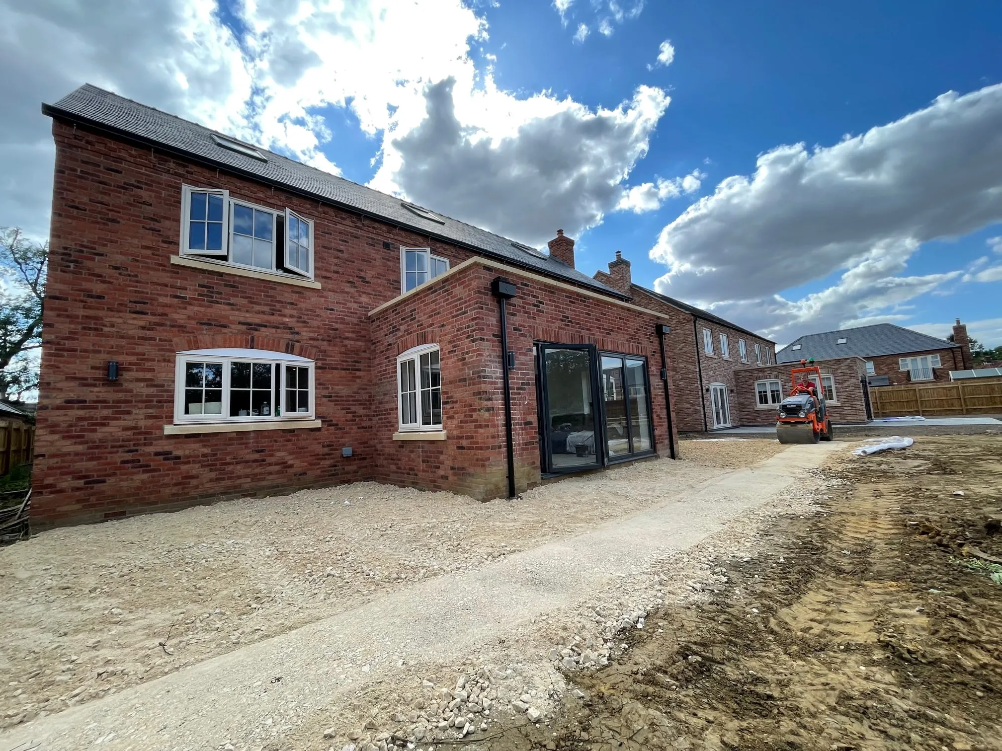A large brick house under construction, now complete with windows and doors.