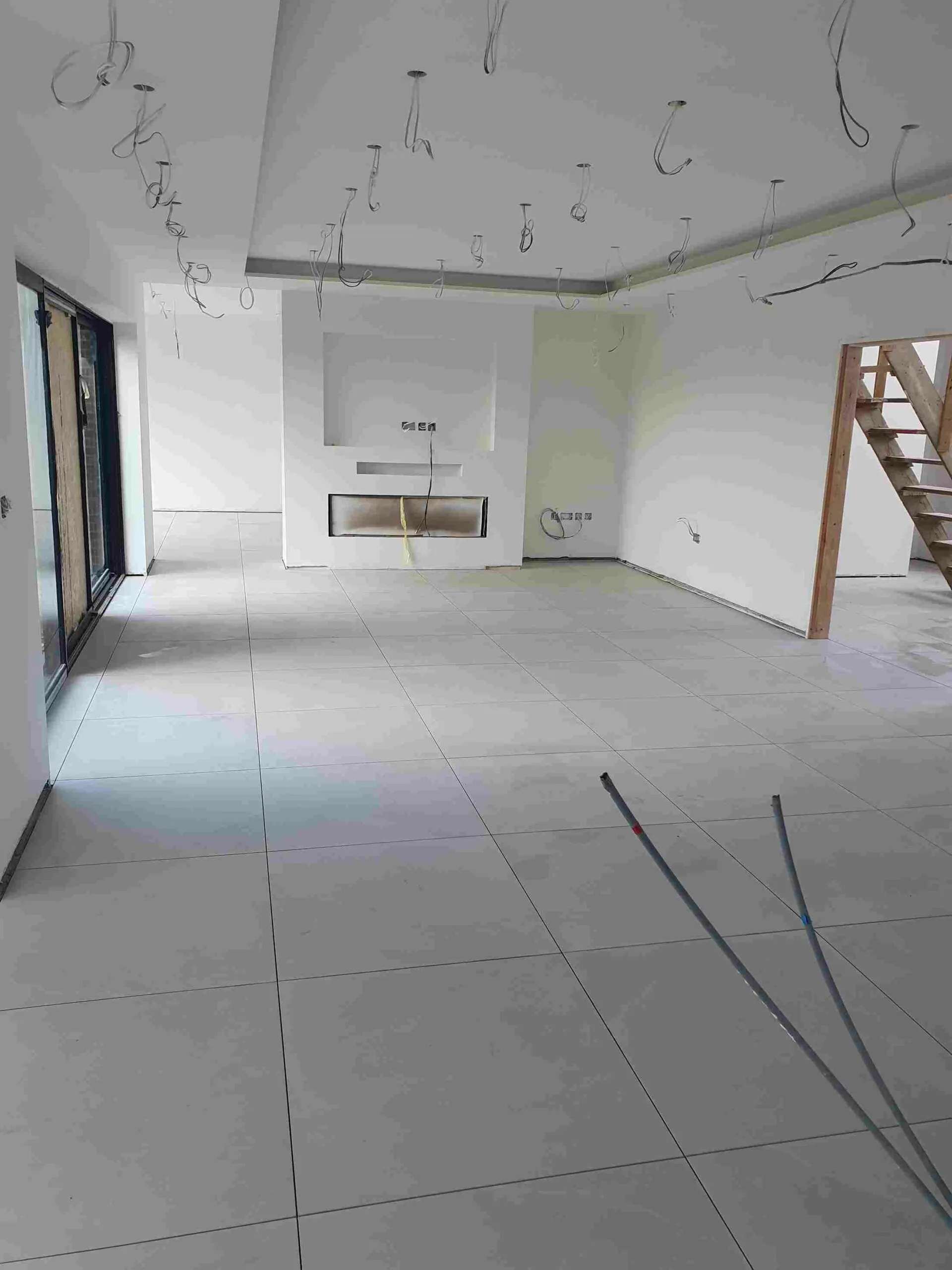 A large white room with a fireplace and a staircase.