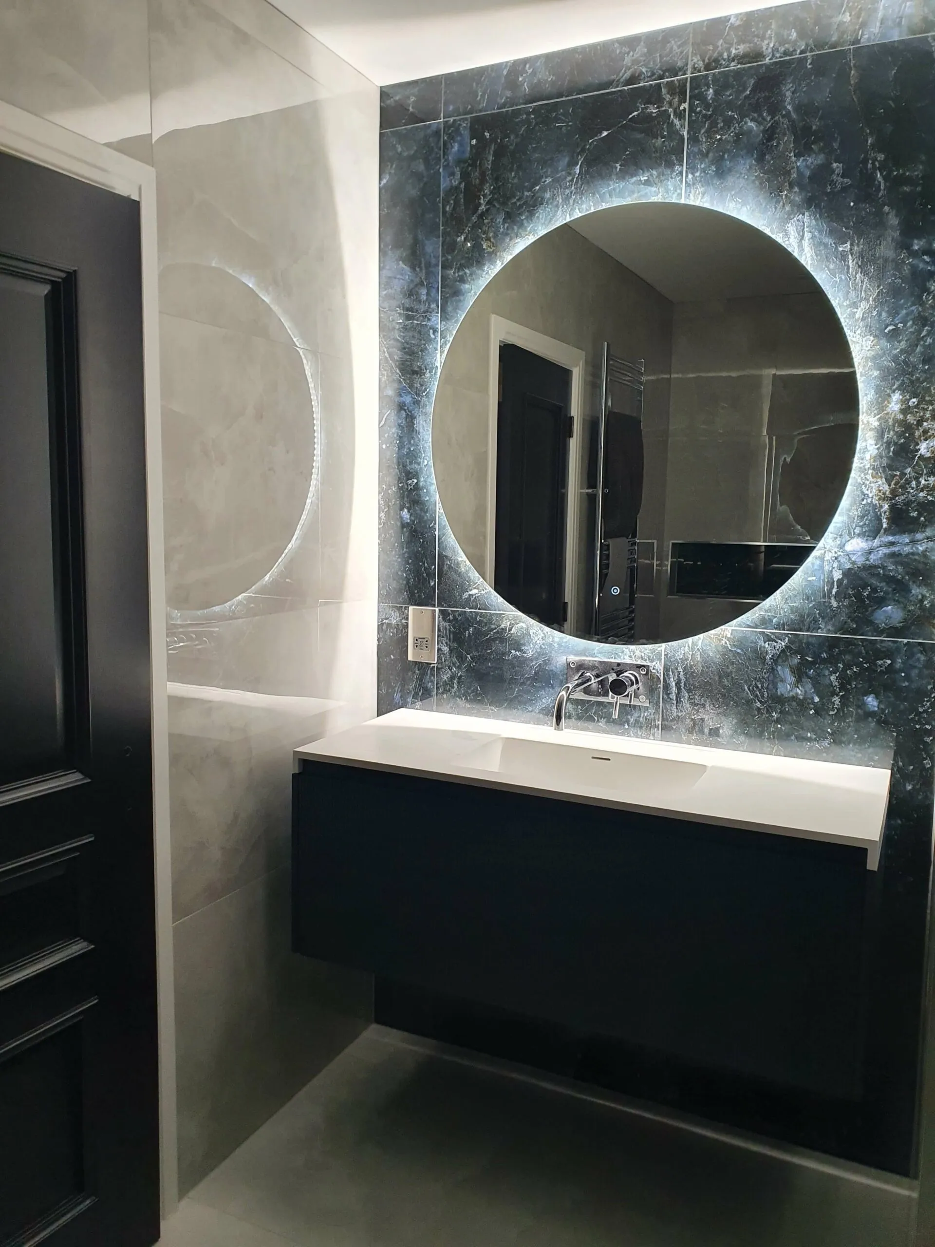 A bathroom with a sink and a large mirror.