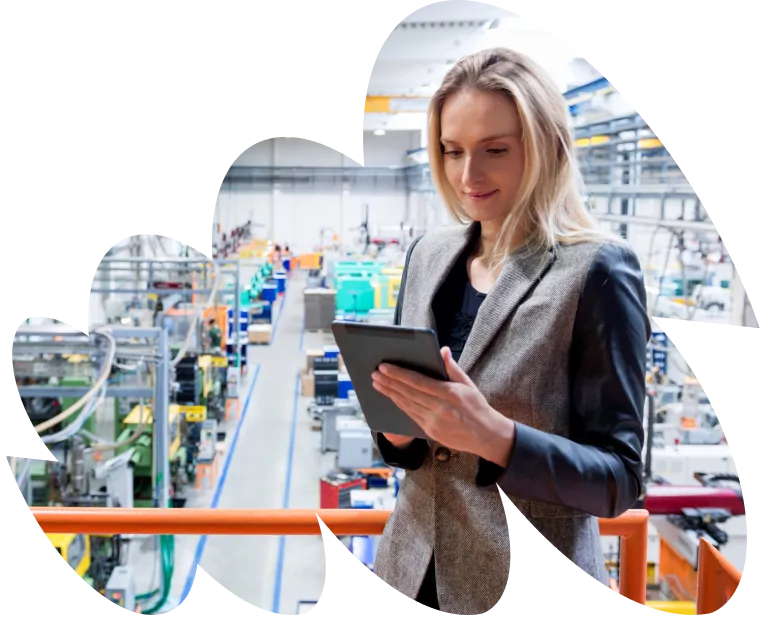 Businesswoman holding a tablet while standing in a large industrial facility