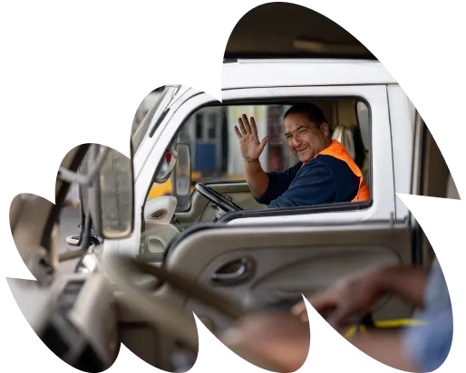 White delivery van driving on a highway with green fields and trees in the background under a clear blue sky