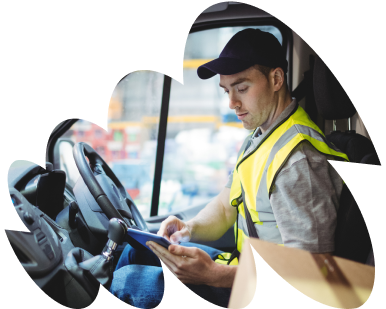 A delivery driver checks his pad in a van