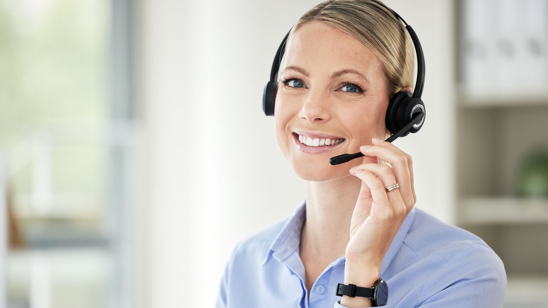 Junge Frau die am Headset telefoniert