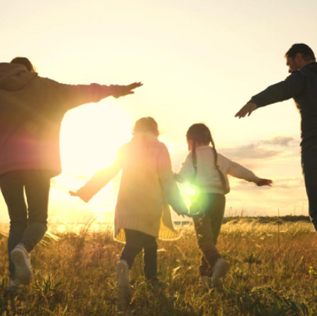 Familie auf einem Feld im Sonnenuntergang