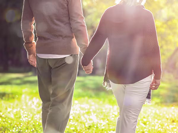 Zwei menschen laufen hand in hand über eine Blumenwiese