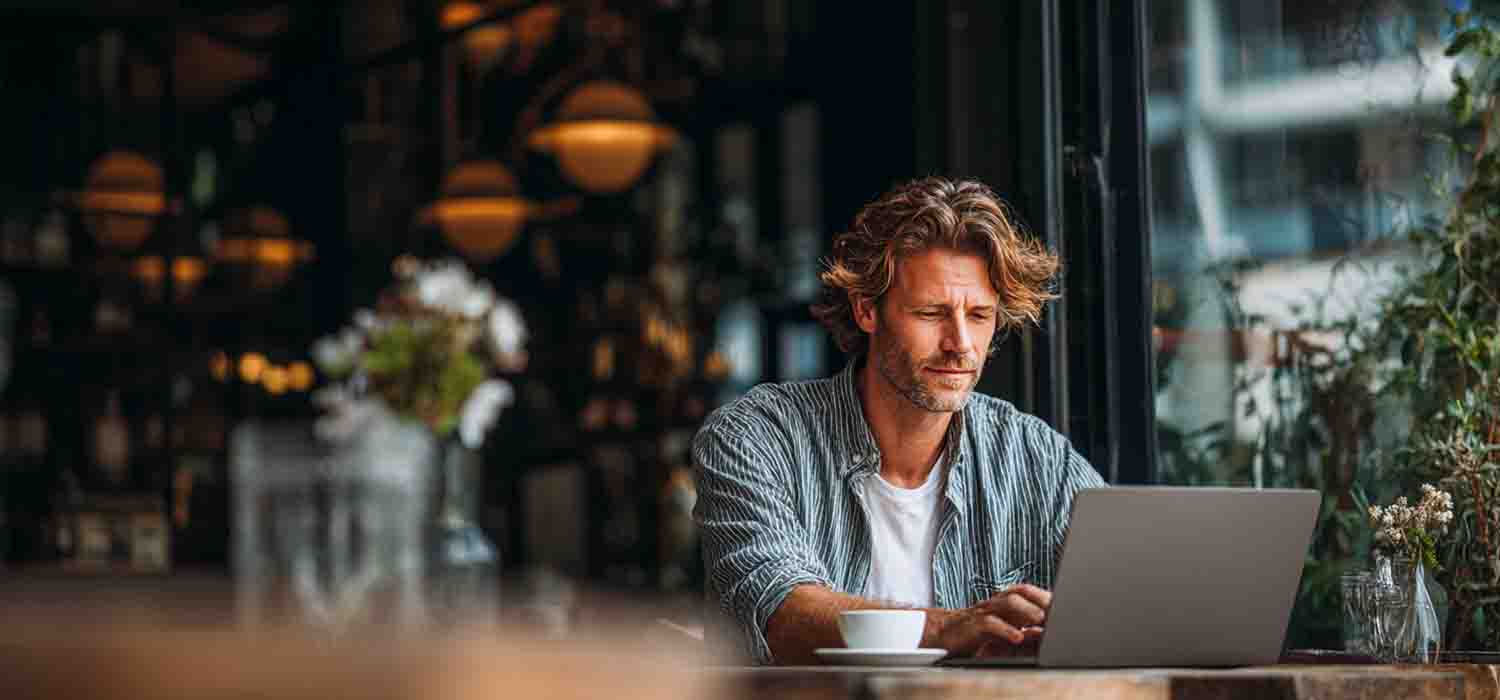 Small business owner accessing cloud services remotely on a laptop in a café