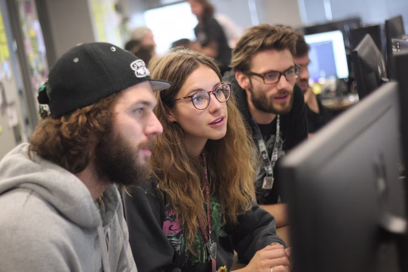 IT team collaborating around monitors