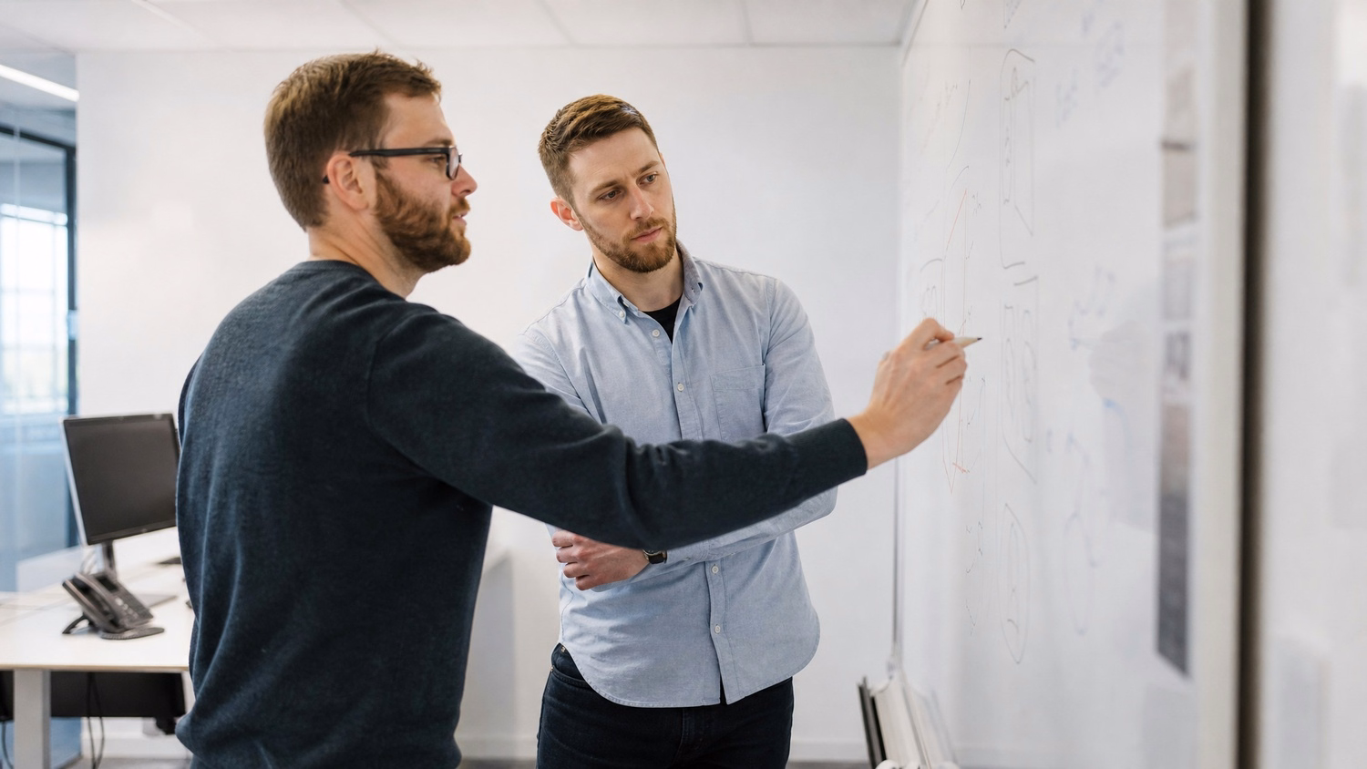 WHITEBOARD SESSION An IT professional  one or two people standing at a whiteb