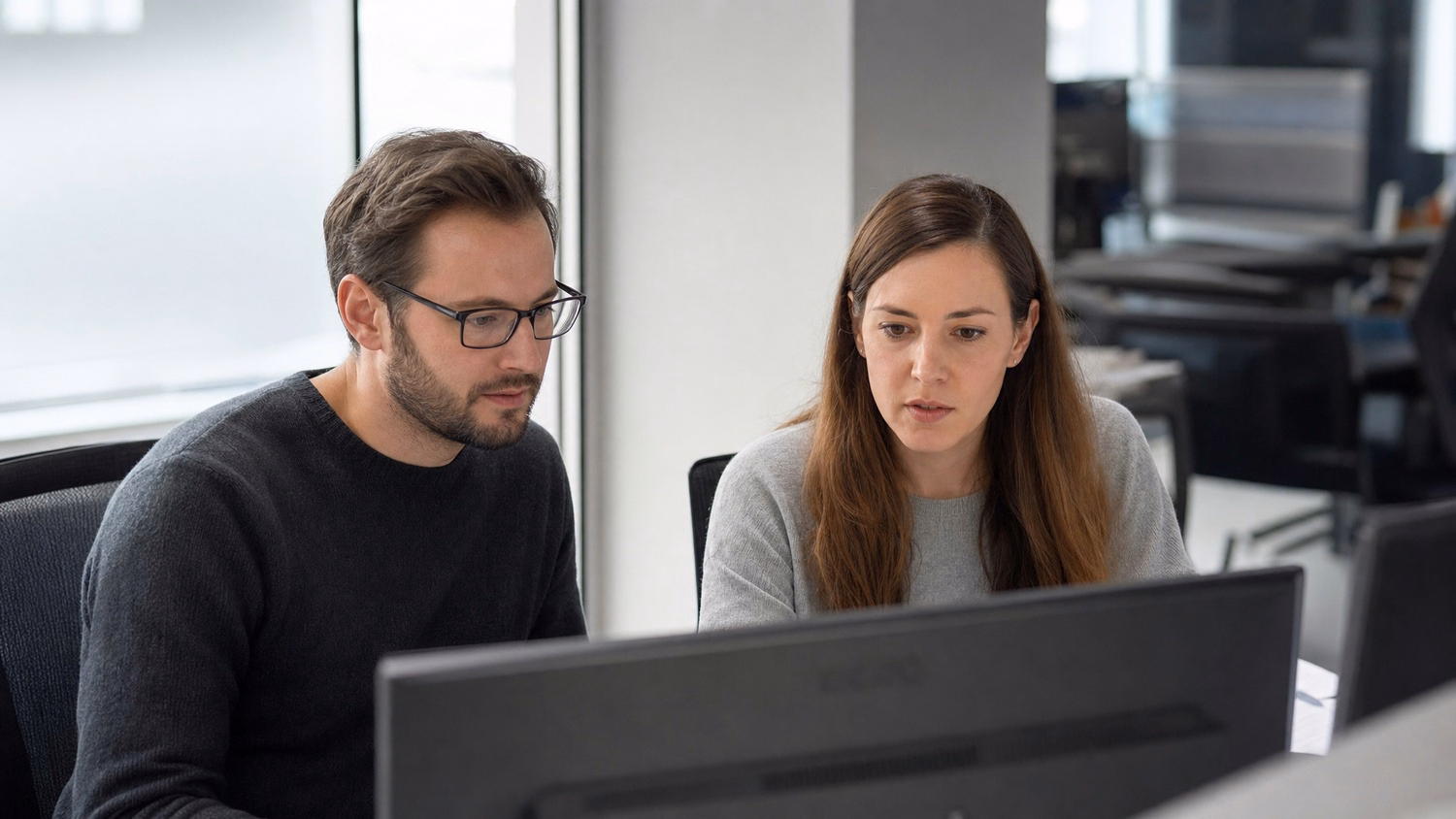 SIDE-BY-SIDE PAIR An IT professional  two people seated side by side reviewin