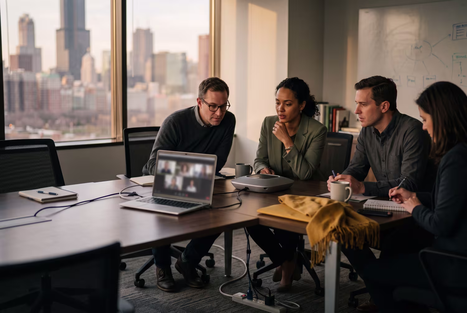 Team engaging with speakerphone and laptop during hybrid meeting in Chicago